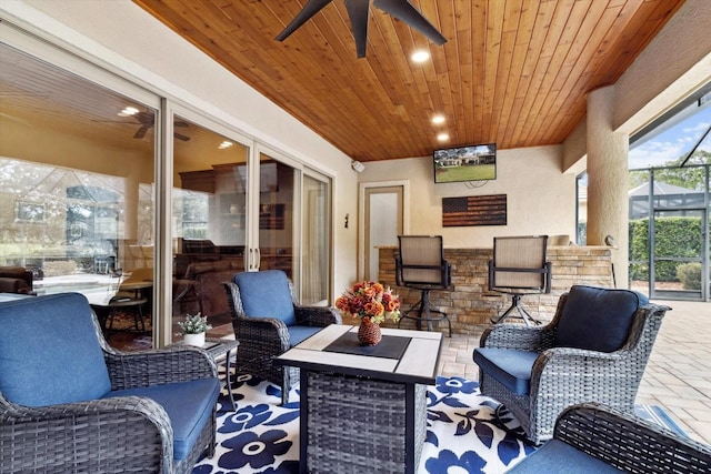 view of patio featuring outdoor lounge area, ceiling fan, and a lanai