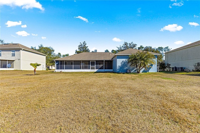 back of house with a lawn and a sunroom