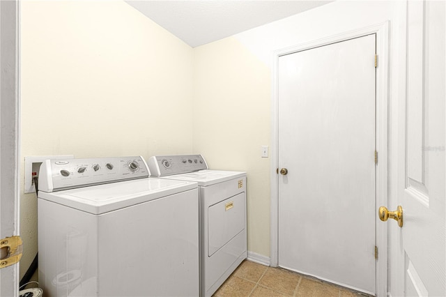 laundry area with washing machine and clothes dryer and light tile patterned floors