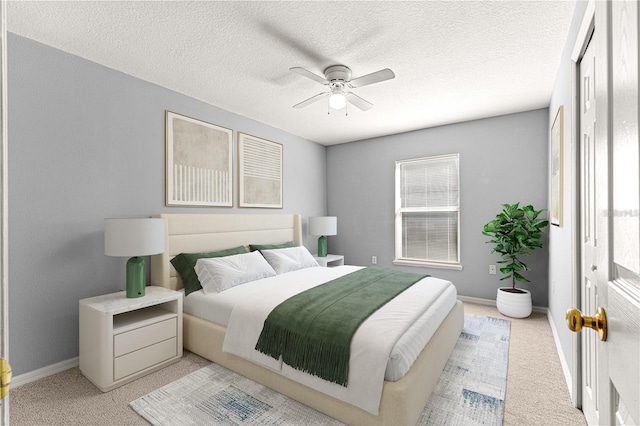 bedroom with ceiling fan, light carpet, and a textured ceiling