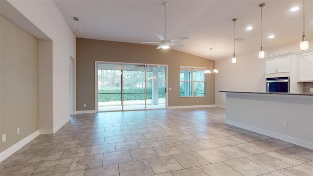 unfurnished living room featuring vaulted ceiling and ceiling fan with notable chandelier