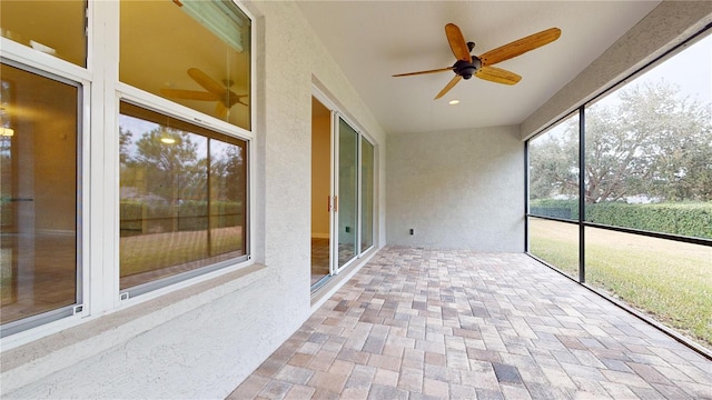 unfurnished sunroom featuring ceiling fan