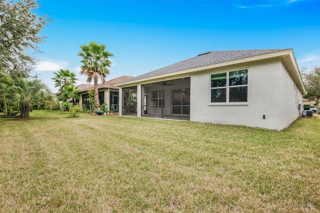 rear view of property featuring a sunroom, a yard, central AC unit, and ceiling fan