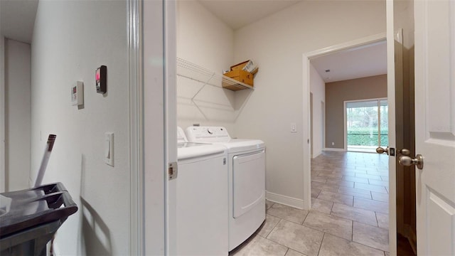 laundry room with washing machine and dryer and light tile patterned floors