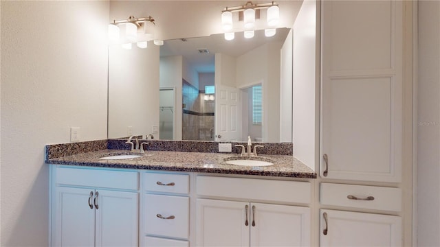 bathroom with vanity and a shower with door