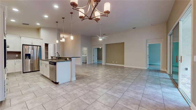 kitchen with white cabinetry, stainless steel appliances, sink, and an island with sink