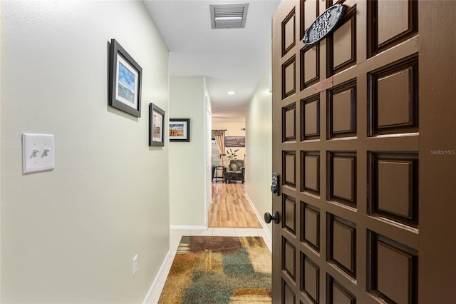 hall featuring light tile patterned floors