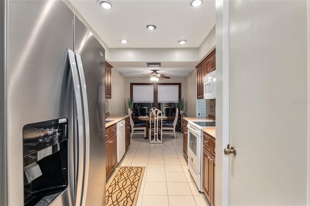 kitchen featuring ceiling fan, light tile patterned floors, and white appliances