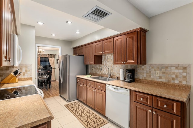 kitchen featuring light tile patterned flooring, appliances with stainless steel finishes, tasteful backsplash, and sink