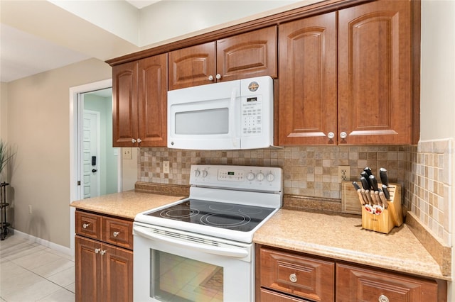 kitchen featuring light tile patterned floors, tasteful backsplash, and white appliances