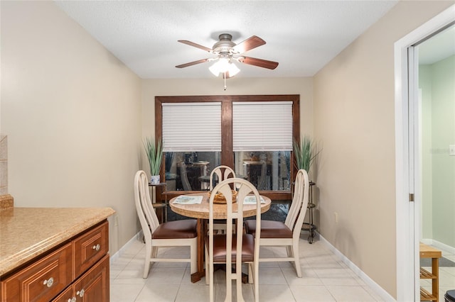 dining space featuring a textured ceiling, ceiling fan, and light tile patterned floors