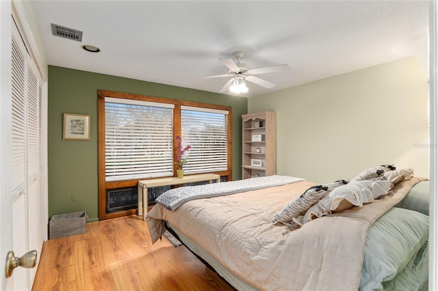 bedroom featuring ceiling fan, a closet, and wood-type flooring