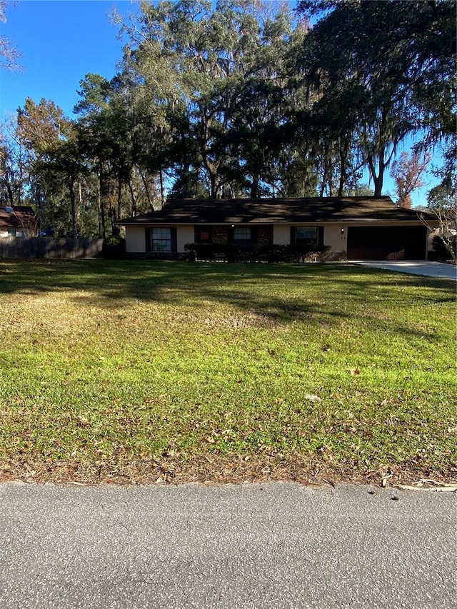 ranch-style home featuring a garage and a front yard