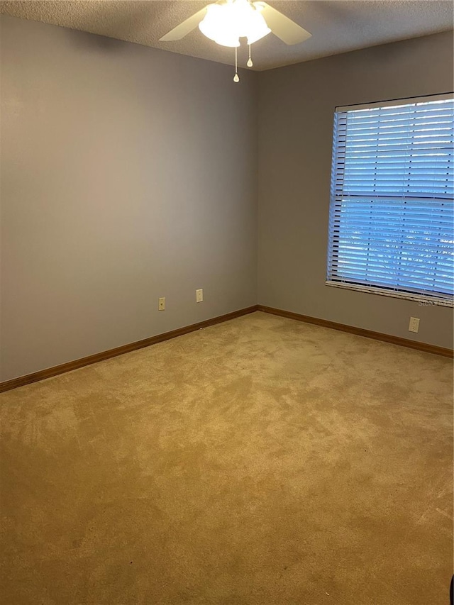 empty room with a textured ceiling, ceiling fan, and light carpet