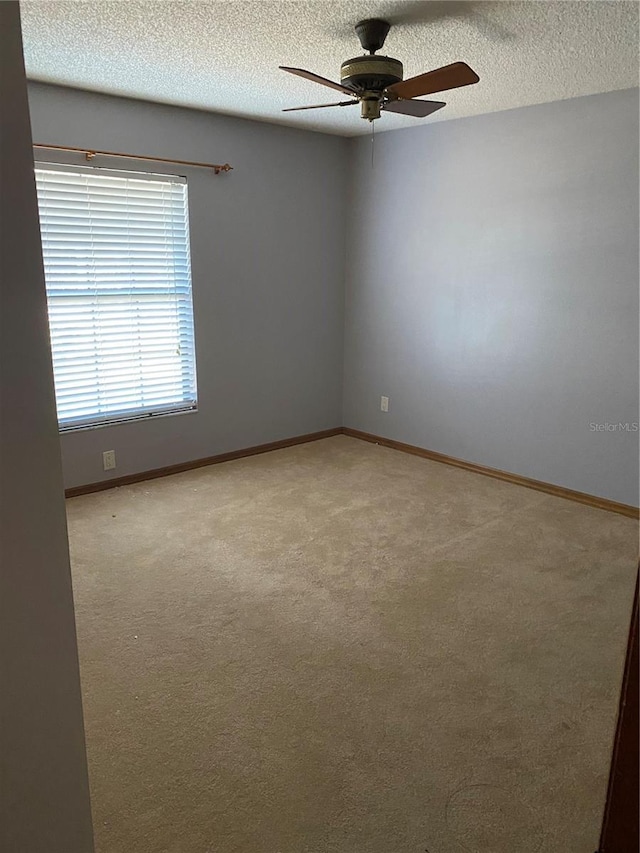 unfurnished room featuring ceiling fan, a textured ceiling, and light carpet