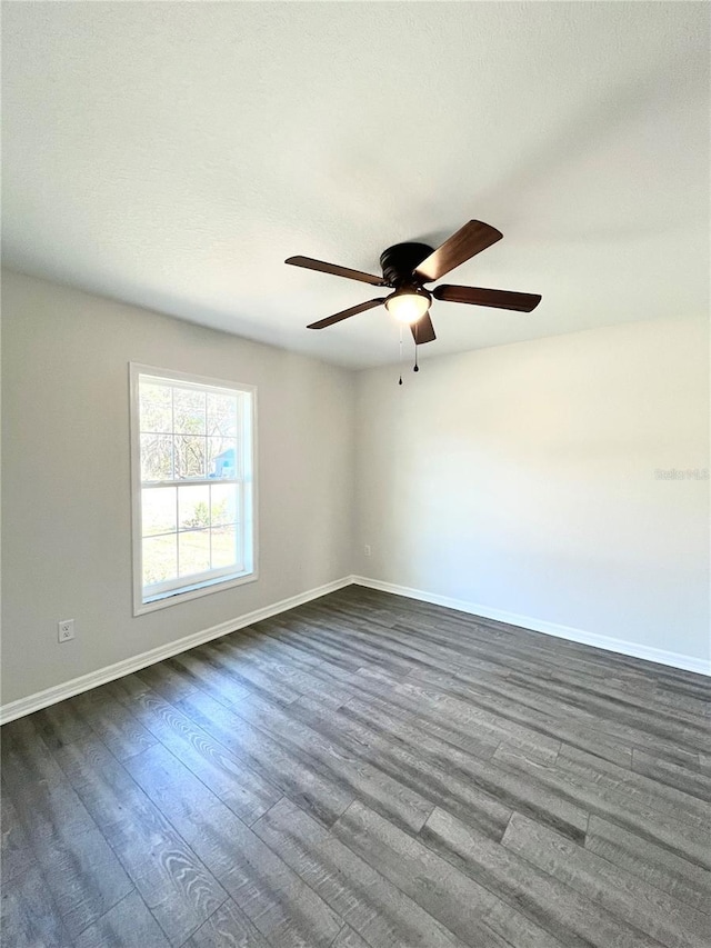 empty room with dark wood-type flooring and ceiling fan