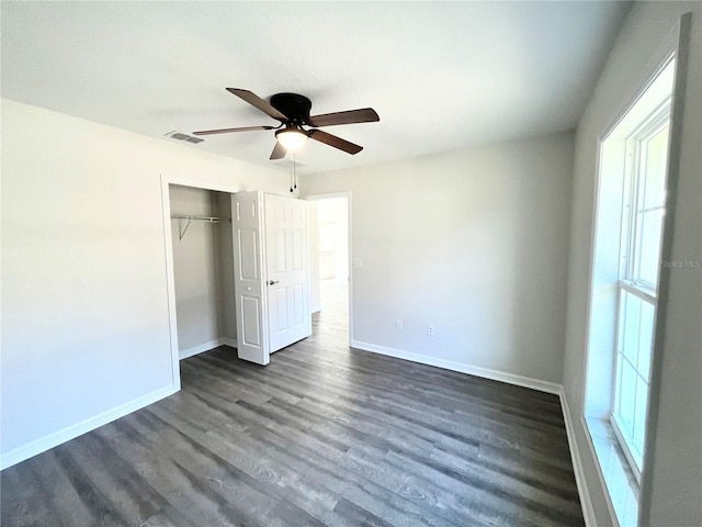 unfurnished bedroom with ceiling fan, a closet, and dark hardwood / wood-style floors