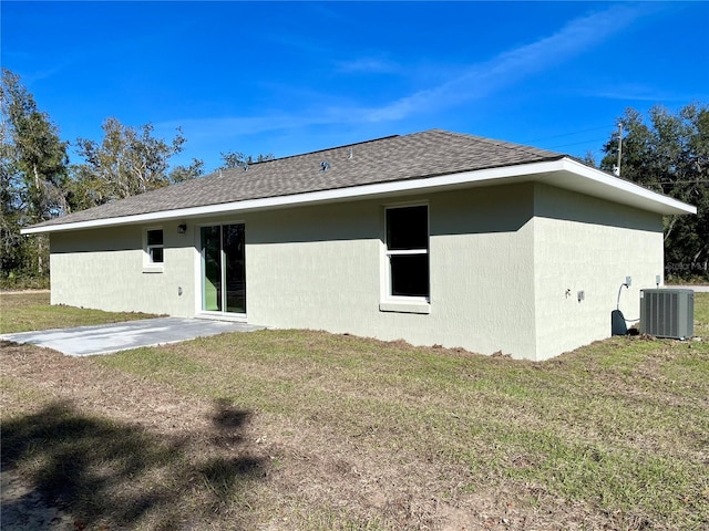 rear view of property with a lawn, cooling unit, and a patio area