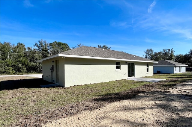 back of house featuring a patio area and a yard