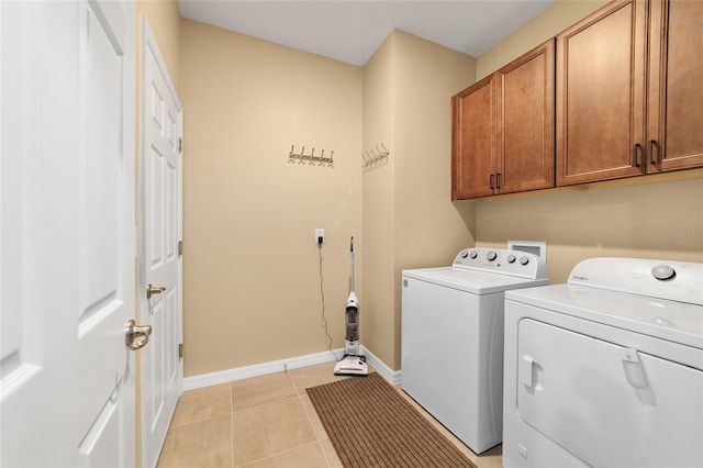 laundry room with cabinets, light tile patterned floors, and independent washer and dryer