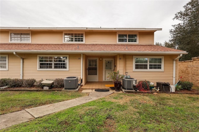 view of front of home with a front yard and central AC unit