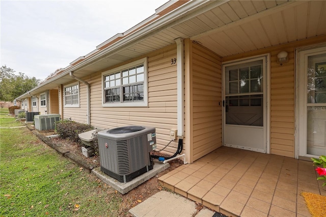 exterior space featuring central air condition unit, a yard, and a patio area