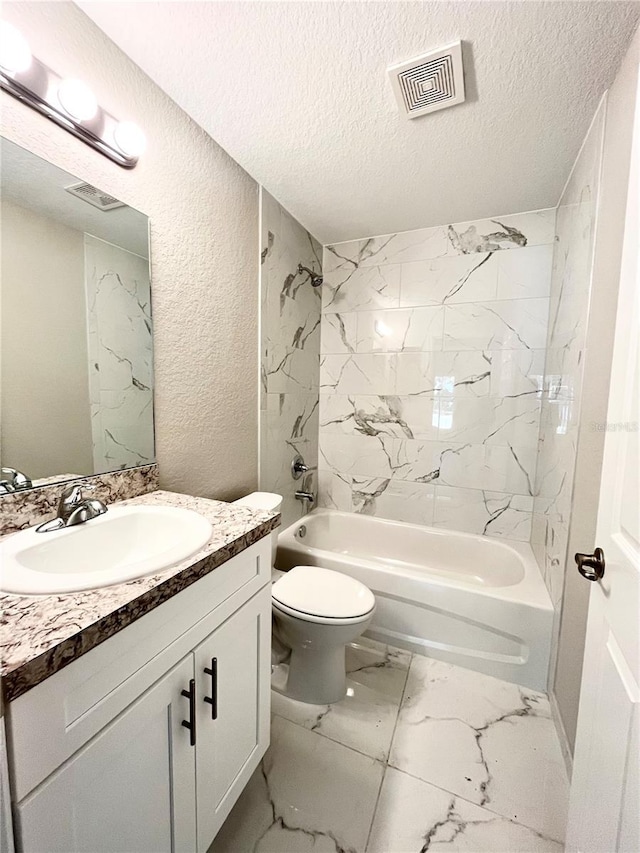 full bathroom featuring a textured ceiling, toilet, tiled shower / bath combo, and vanity