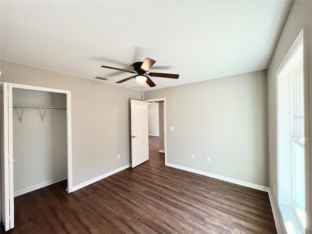 unfurnished bedroom with ceiling fan, a closet, and dark hardwood / wood-style flooring