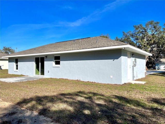 rear view of property featuring a patio area and a yard