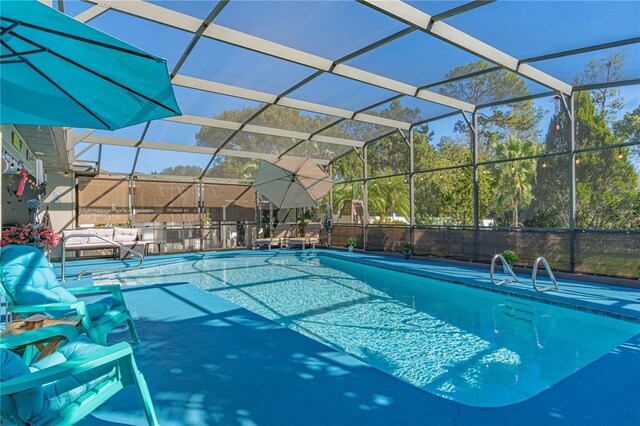 view of swimming pool featuring glass enclosure