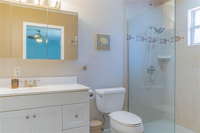 bathroom featuring tiled shower, vanity, and toilet