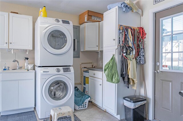 washroom featuring cabinets, a wealth of natural light, stacked washer / drying machine, and sink