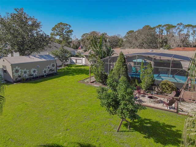 view of yard featuring a fire pit, a patio, and glass enclosure