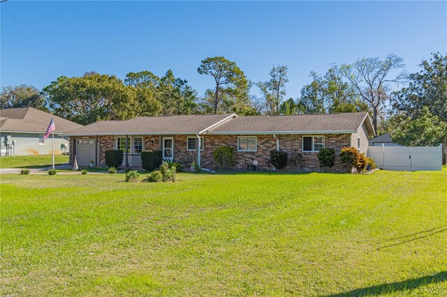 single story home featuring a garage and a front yard