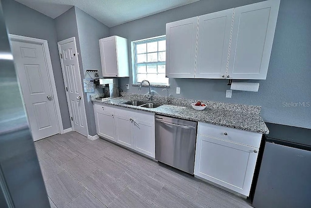 kitchen featuring sink, dishwasher, stone counters, and white cabinets