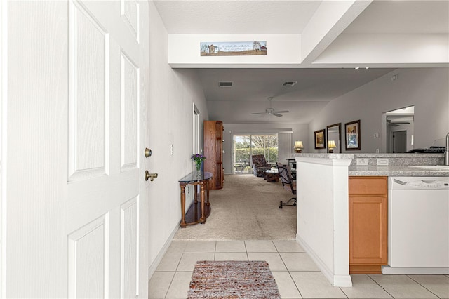 hall featuring sink and light tile patterned flooring