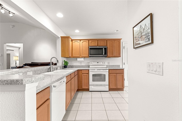 kitchen featuring light tile patterned flooring, sink, light stone counters, kitchen peninsula, and white appliances