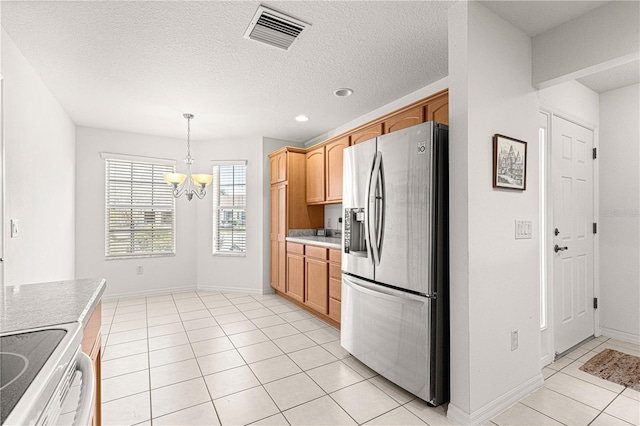 kitchen featuring stainless steel refrigerator with ice dispenser, pendant lighting, a chandelier, light tile patterned floors, and electric stove