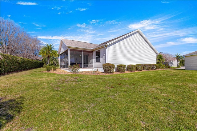 rear view of property featuring a sunroom and a lawn