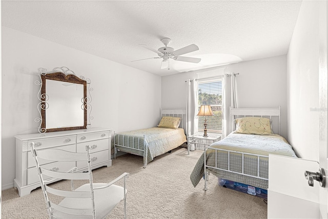 carpeted bedroom with ceiling fan and a textured ceiling