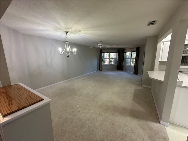 interior space featuring ceiling fan with notable chandelier and light colored carpet