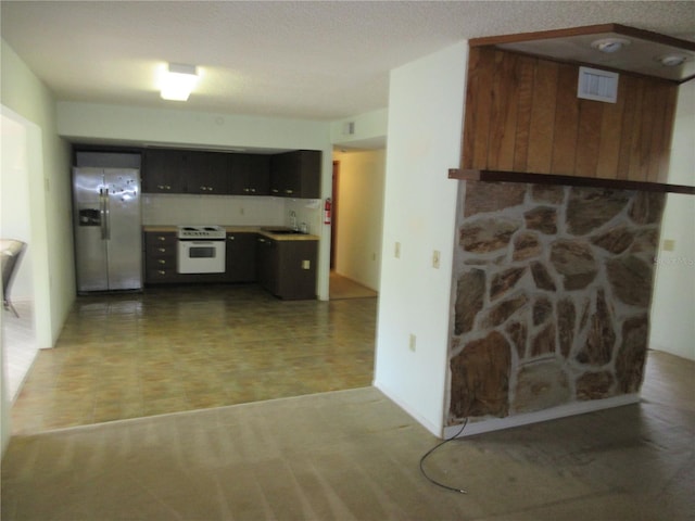 kitchen with stainless steel refrigerator with ice dispenser, electric range, and sink