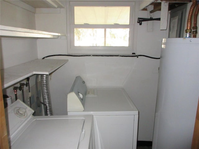 laundry room with separate washer and dryer and water heater