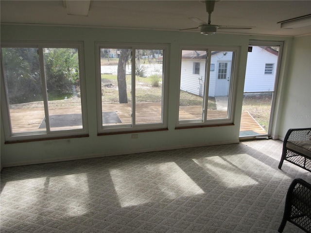 unfurnished sunroom with ceiling fan and a healthy amount of sunlight