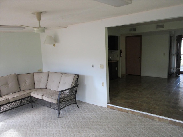 living room featuring ceiling fan and dark carpet