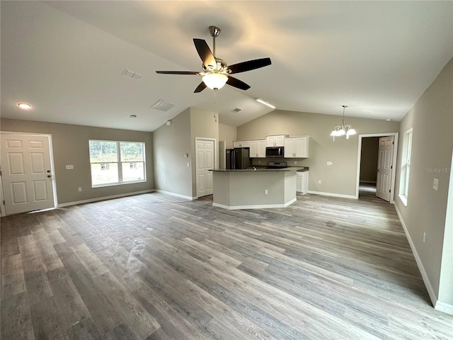 unfurnished living room with ceiling fan with notable chandelier, light hardwood / wood-style flooring, and vaulted ceiling