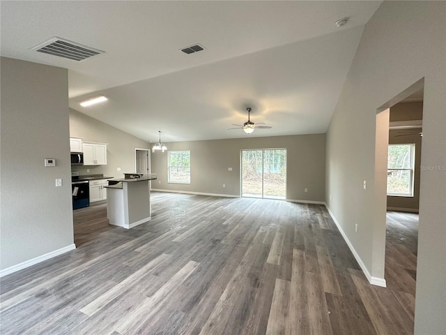 unfurnished living room featuring lofted ceiling, ceiling fan with notable chandelier, and hardwood / wood-style floors