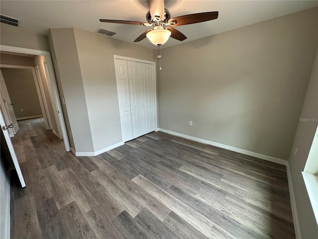 unfurnished bedroom featuring a closet, dark hardwood / wood-style flooring, and ceiling fan