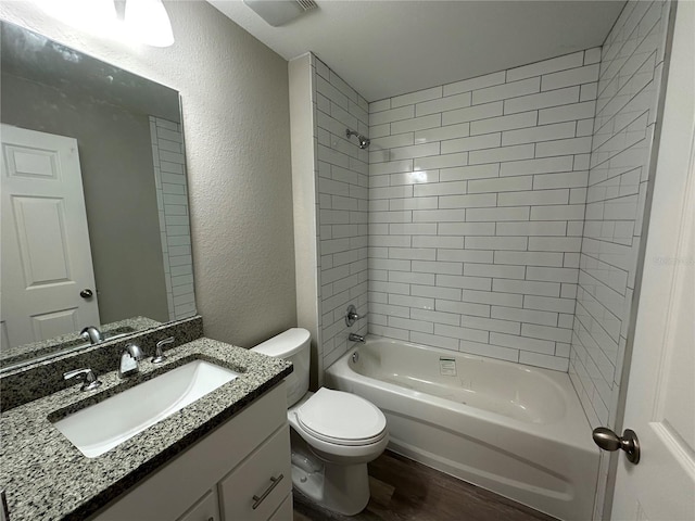 full bathroom with toilet, tiled shower / bath combo, wood-type flooring, and vanity