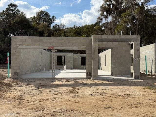 back of house featuring a patio area and concrete block siding